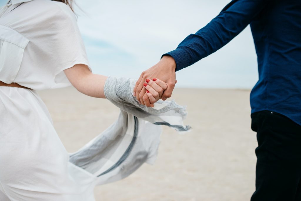couple holding hands on the beach