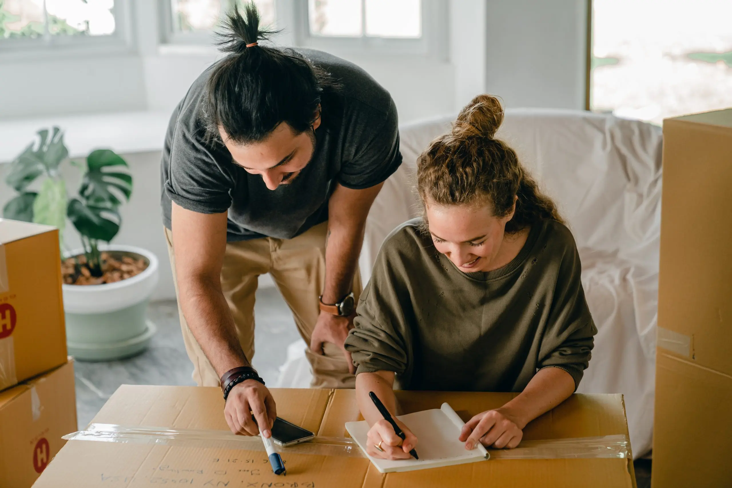 couple moving into new house and writing on piece of paper