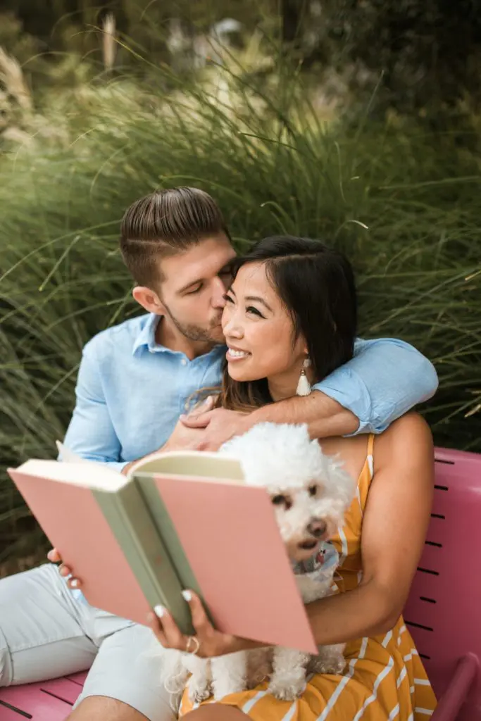 couple reading a book with their dog