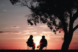 couple sitting in front of a sunset