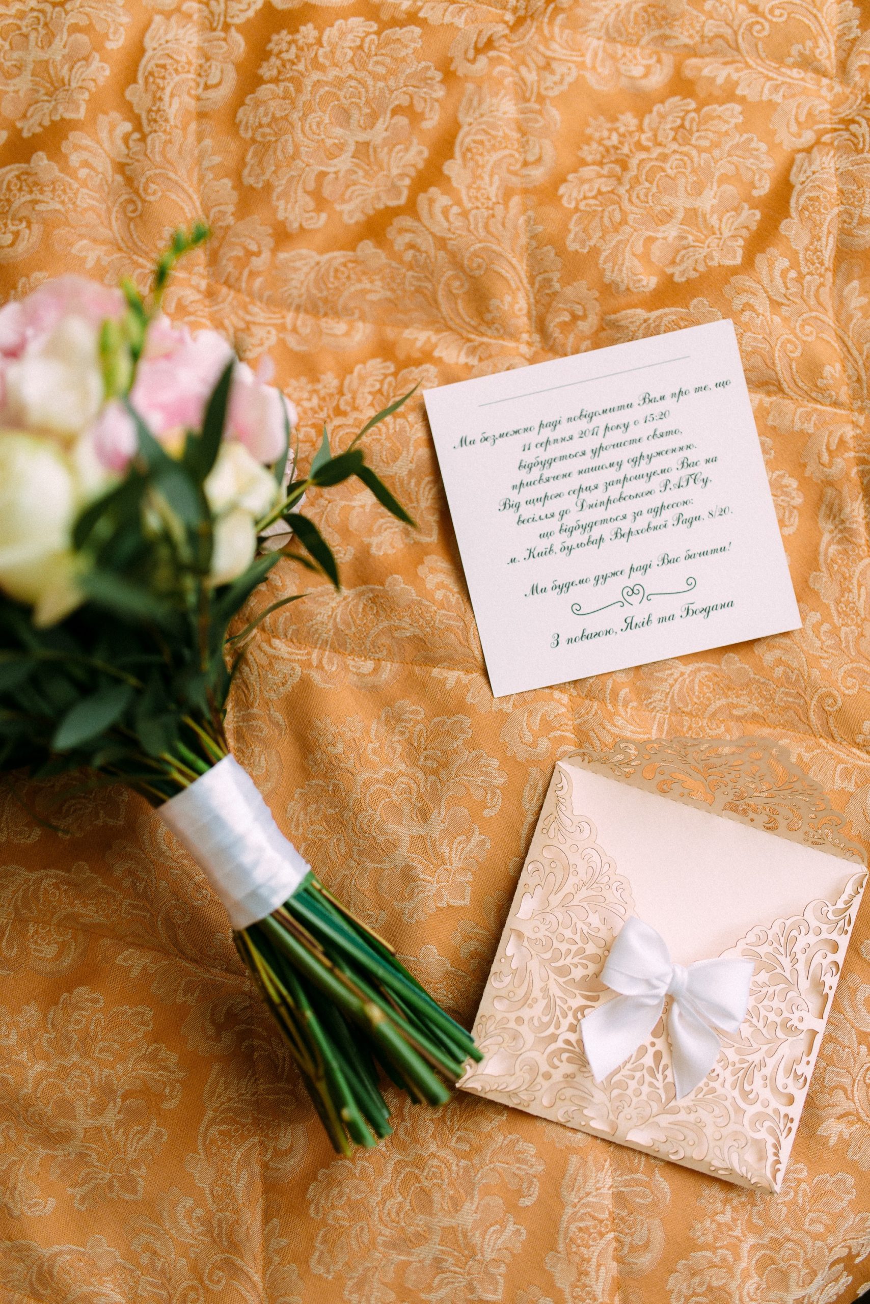 wedding invitation and flowers on a bed