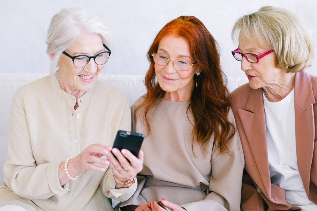 women watching a video of wedding on their phone