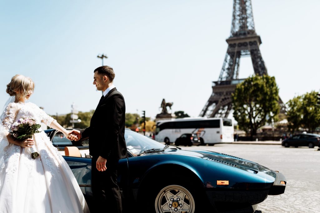 couple standing next to luxury car in paris
