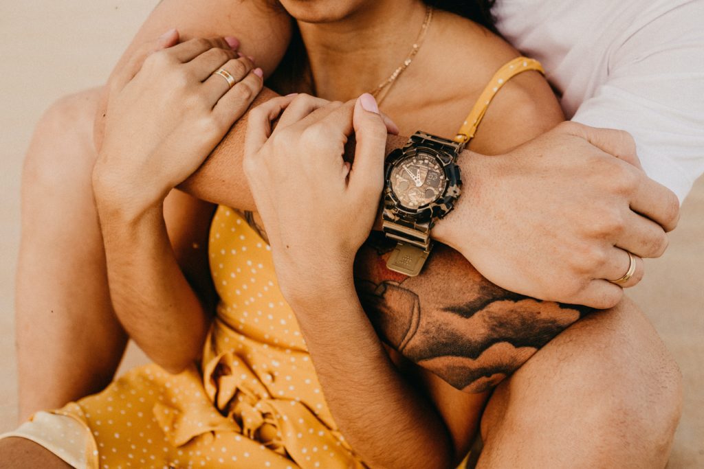 How To Talk To Your Partner About A Lack of Intimacy man with clock hugging woman