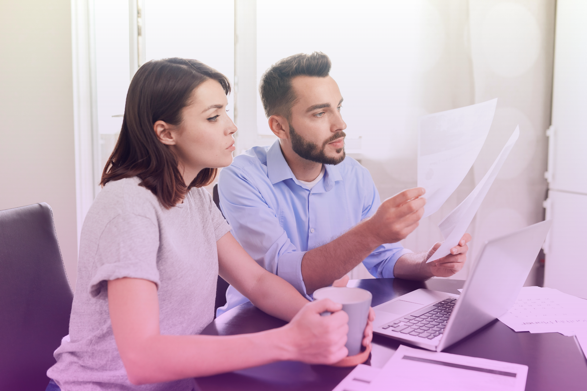 Couple reviewing financial documents together at a table.