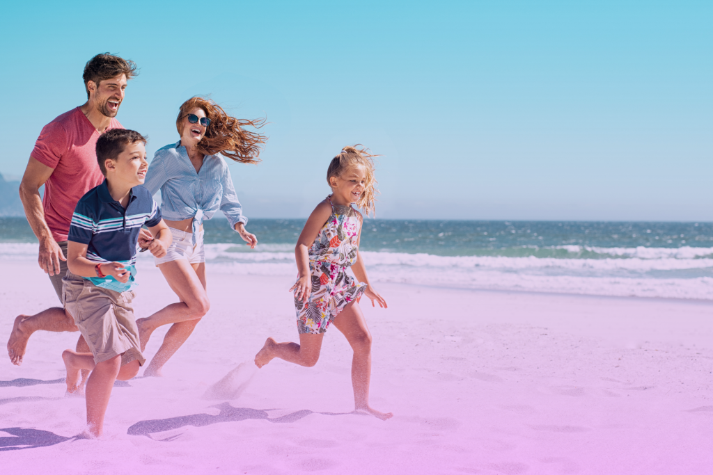 Smiling family with two kids playing on the beach