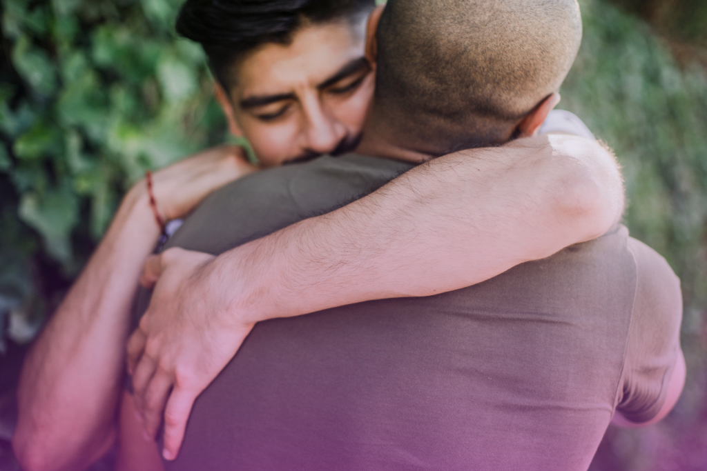 A loving spouse gives their partner a hug with a supportive expression.