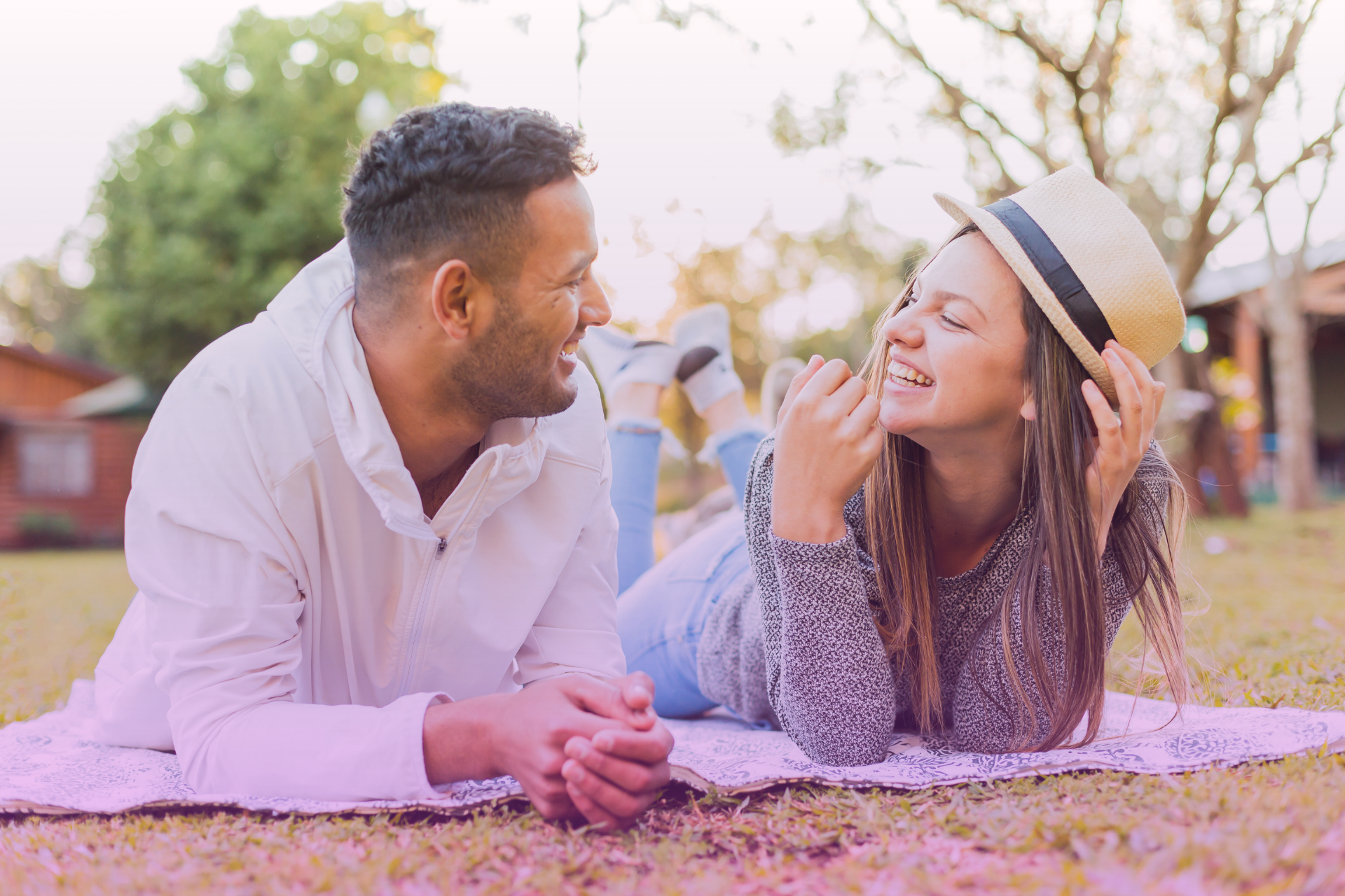 A laughing couple on a park, showing joy and connection.