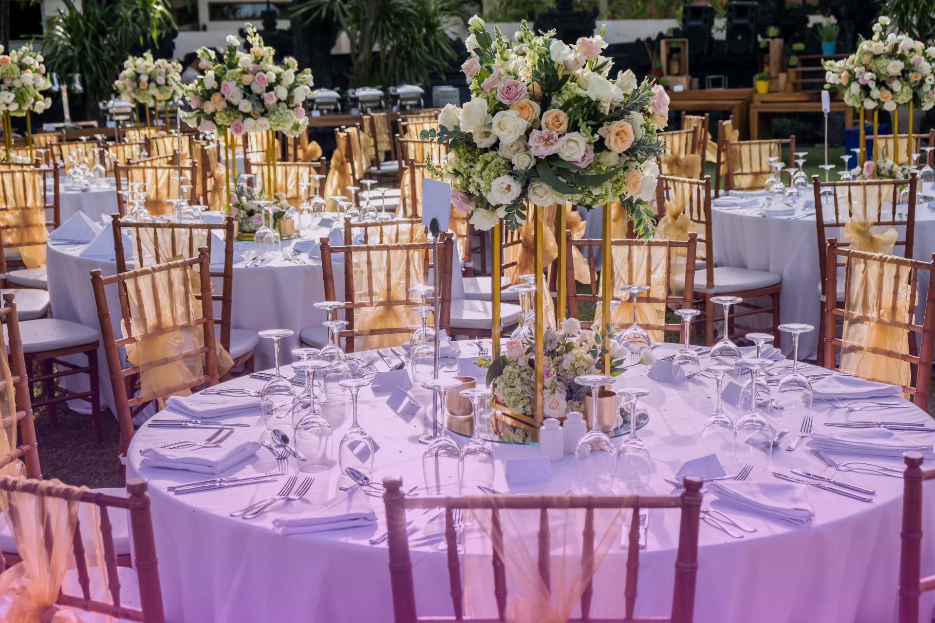 Smiling couple holding a budget binder and a flower, excited about planning their wedding.