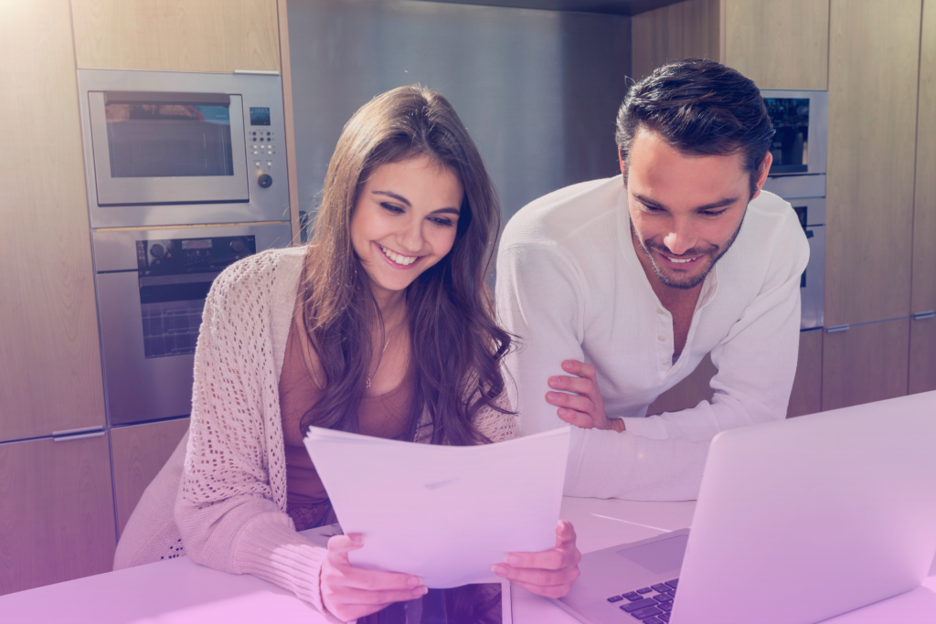 Joyful couple signing a prenuptial agreement with a lawyer present.