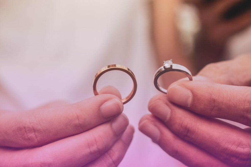 A close-up of wedding rings against a backdrop of a Nebraska cornfield, symbolizing commitment and new beginnings.