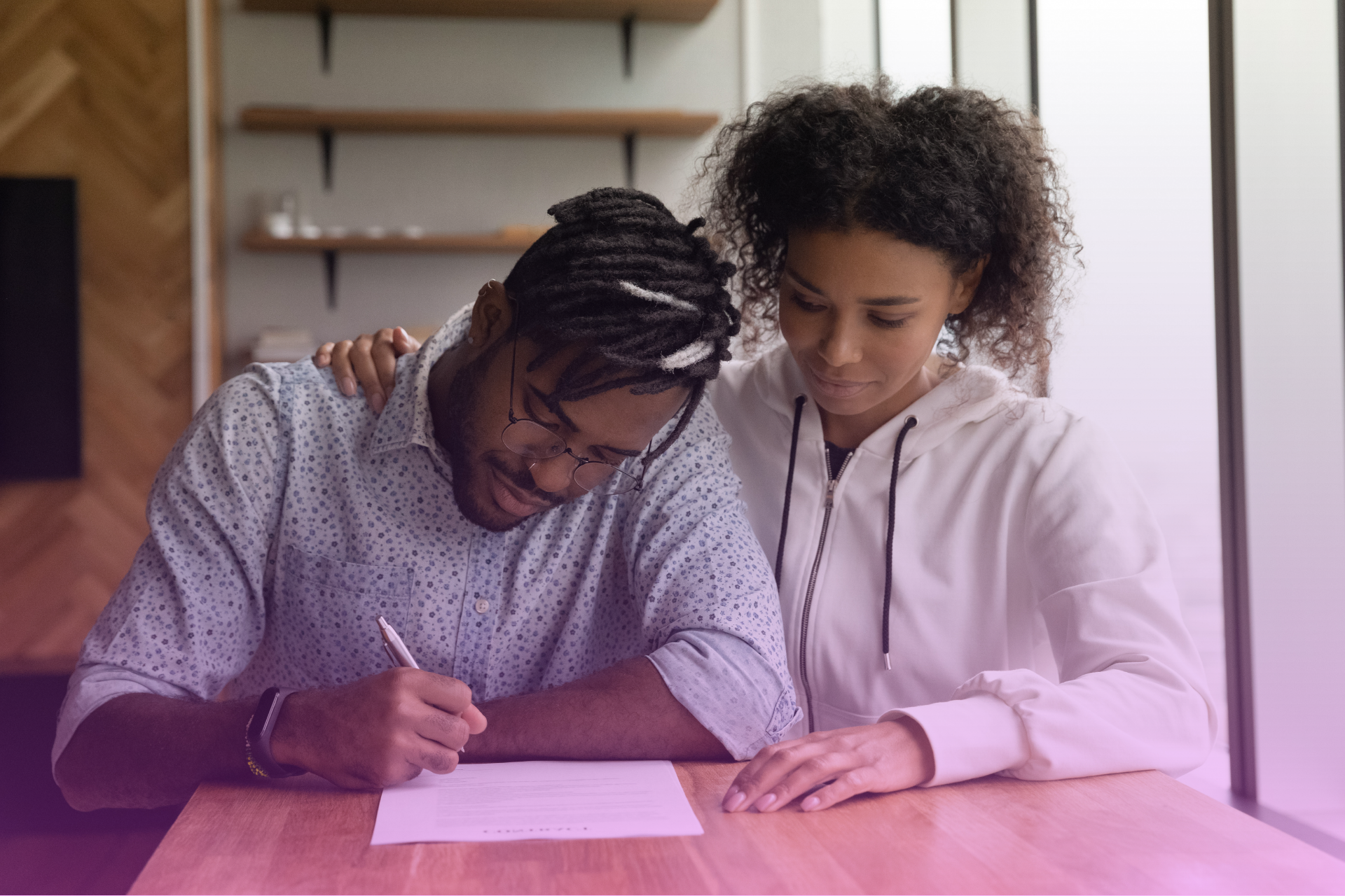 A happy couple reviewing a prenuptial agreement document together.