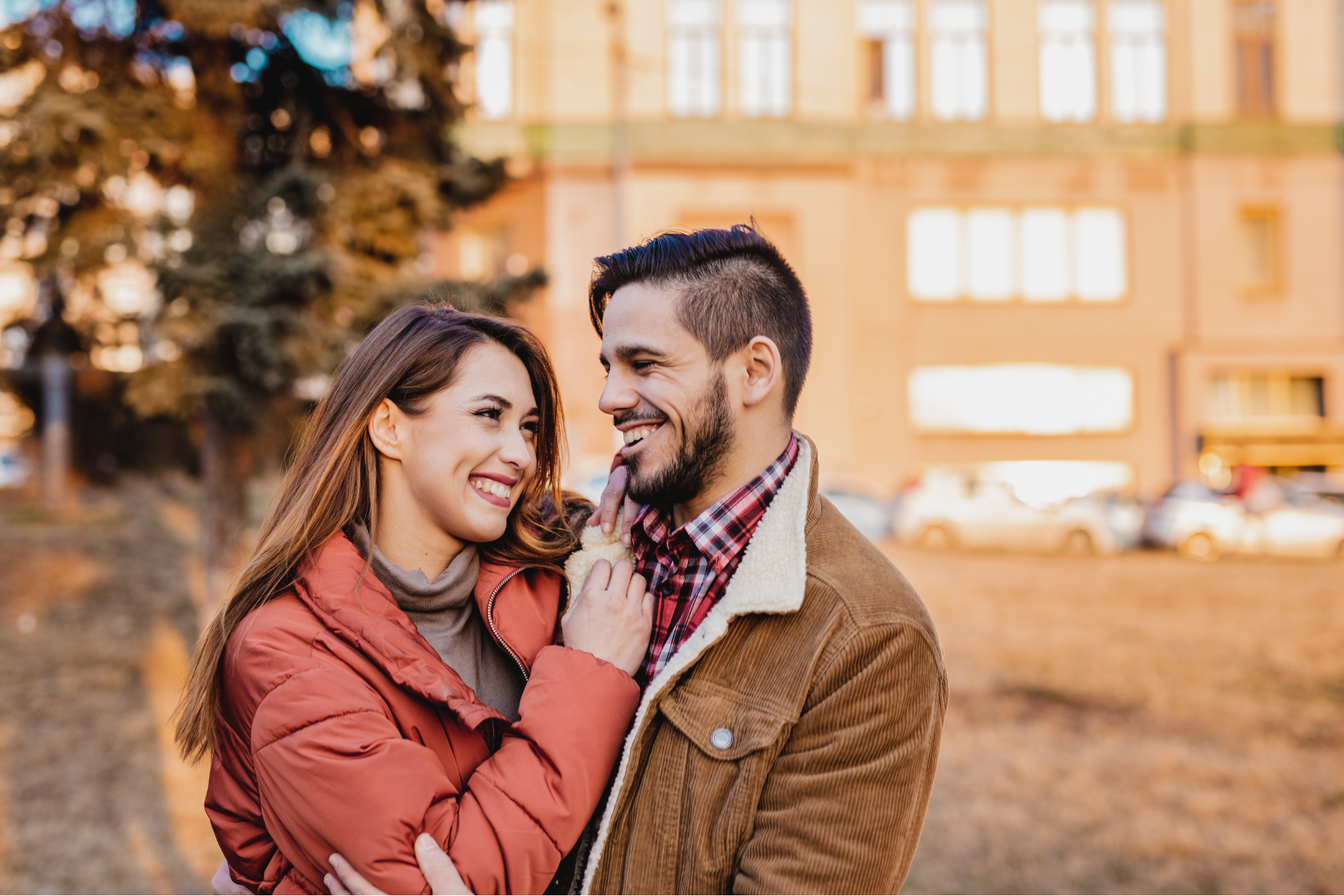 A joyful couple enjoying a beautiful autumn day amidst the vibrant fall foliage in Vermont, surrounded by golden leaves and crisp air, radiating happiness as they embrace the stunning seasonal landscape.