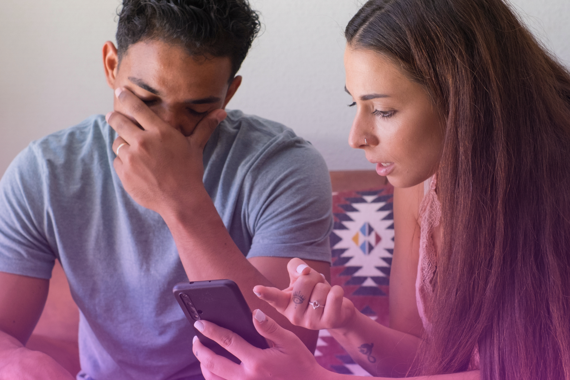 A couple looking at their cellphone with concerned expressions.