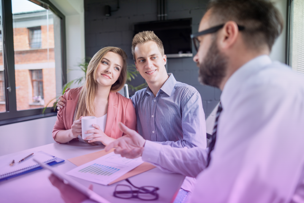A lawyer explaining a legal document to a couple during a consultation.