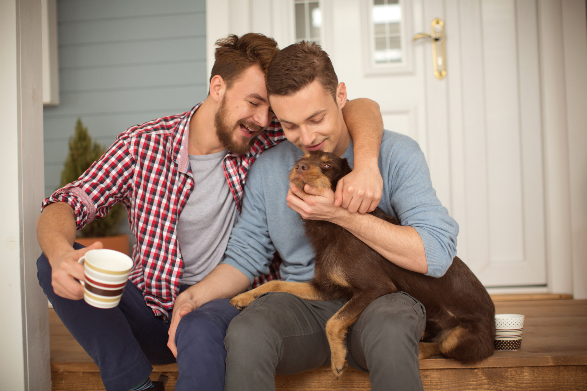 happy couple with their dog in front door
