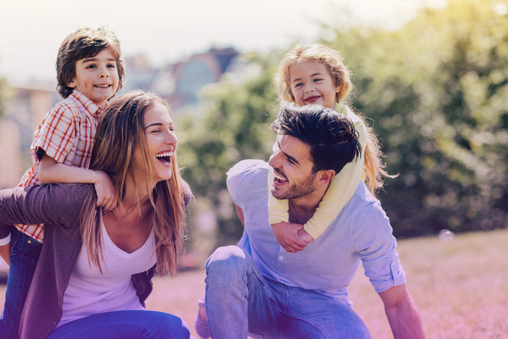 Supportive parents hugging their happy, newly married child and their spouse, symbolizing family unity and respect for their decisions.