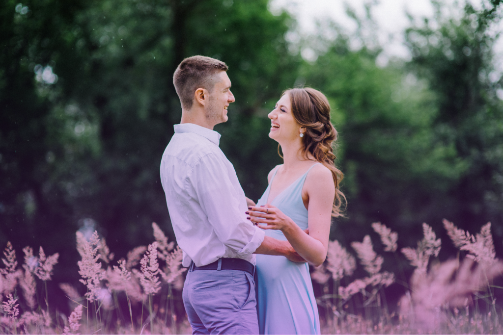 A joyful couple embracing and laughing on a sunny day, symbolizing trust and partnership, key elements in postnuptial agreements.