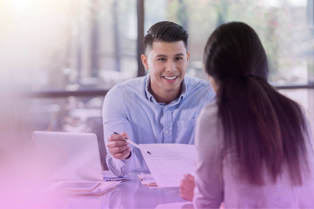 A lawyer handing a postnuptial agreement document to a woman, discussing legal matters.