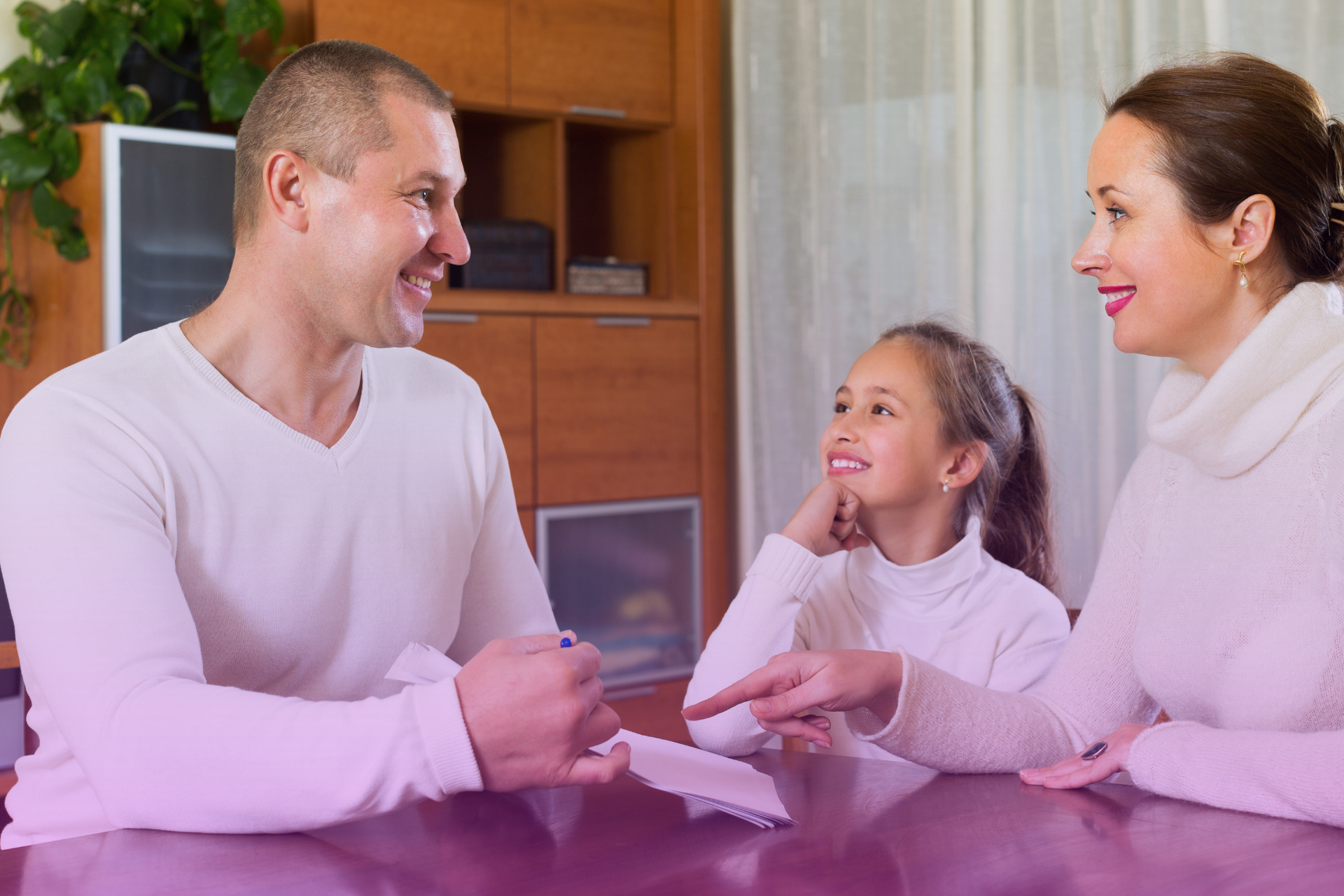 A couple smiles while signing estate planning documents, symbolizing a proactive step towards a secure future.