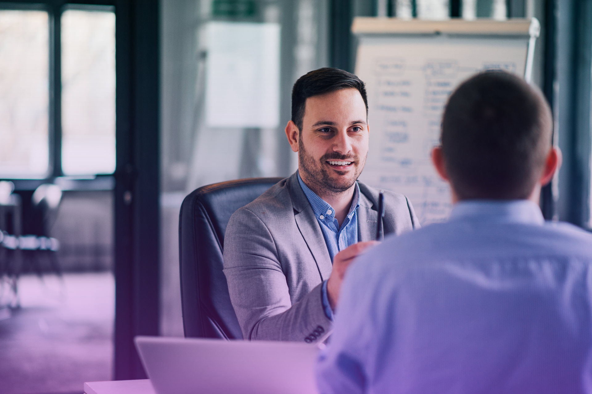 A lawyer gestures while explaining the benefits of estate planning to a client.