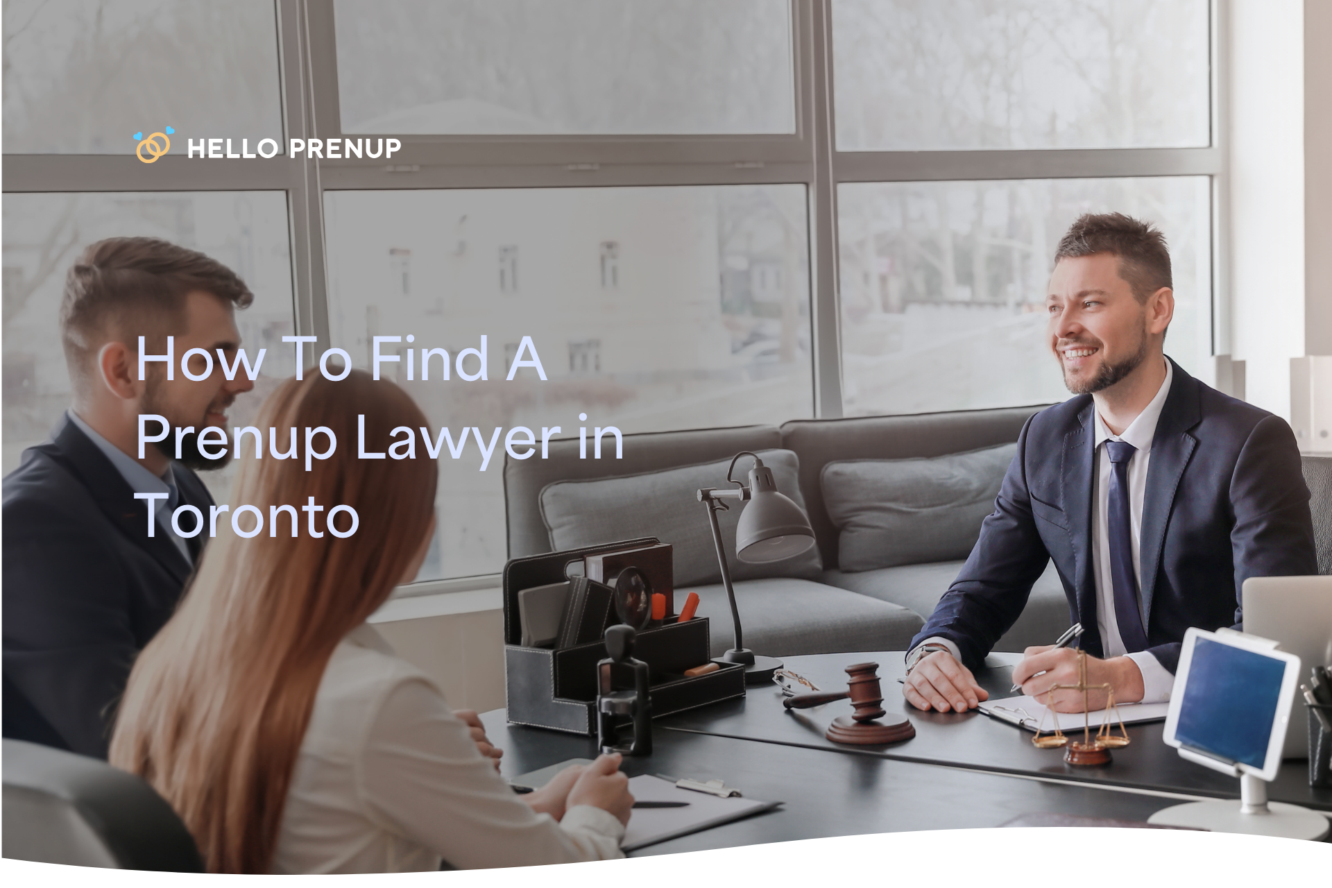 A lawyer and a couple sit at a table in a consultation room, reviewing documents.