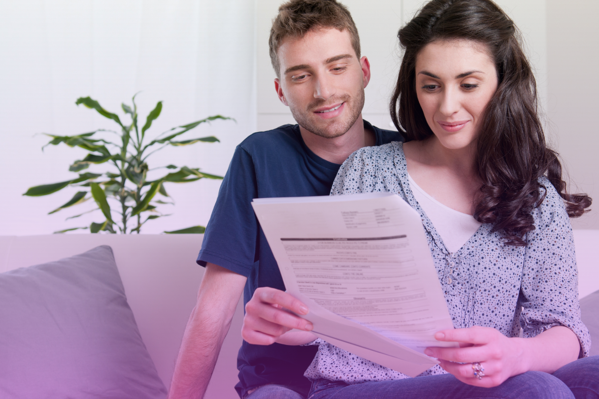 A couple thoughtfully considers the pros and cons of a prenuptial agreement while reviewing documents.