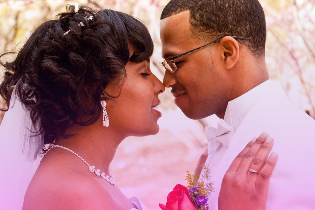 A joyful newlywed couple on their wedding day, gazing into each other's eyes with happiness.