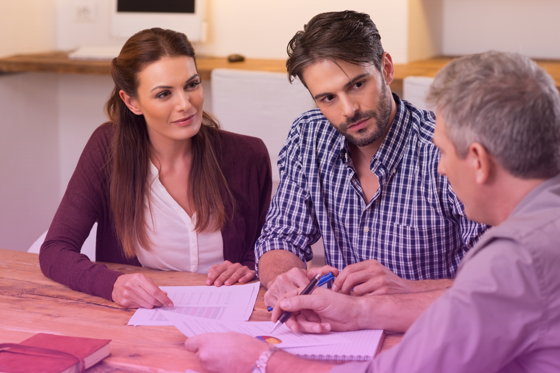 Couple consulting with a financial advisor to incorporate debt management strategies into their postnuptial agreement.