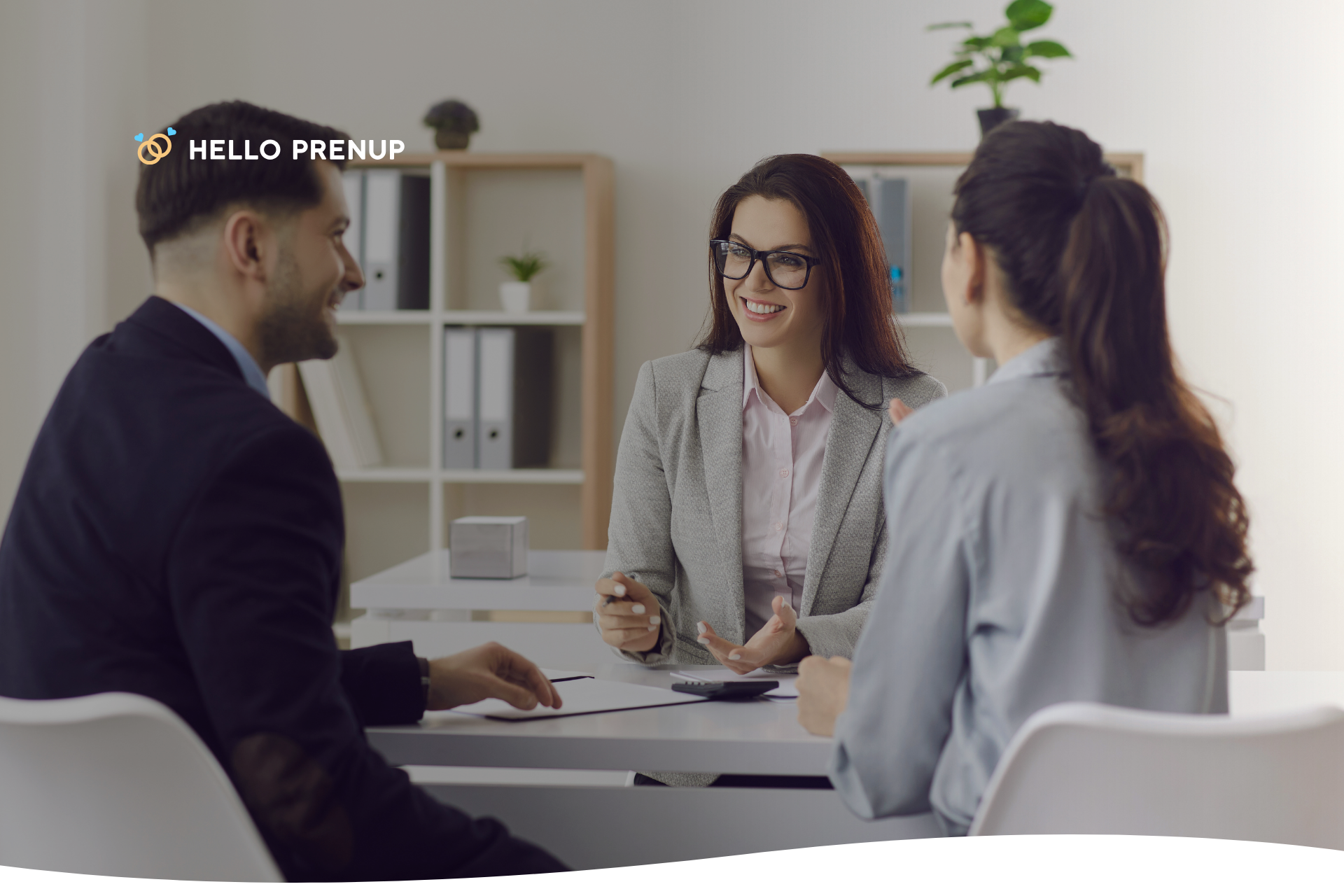 A couple sitting at a table with a legal advisor, discussing the terms and implications of their prenuptial agreement in Massachusetts