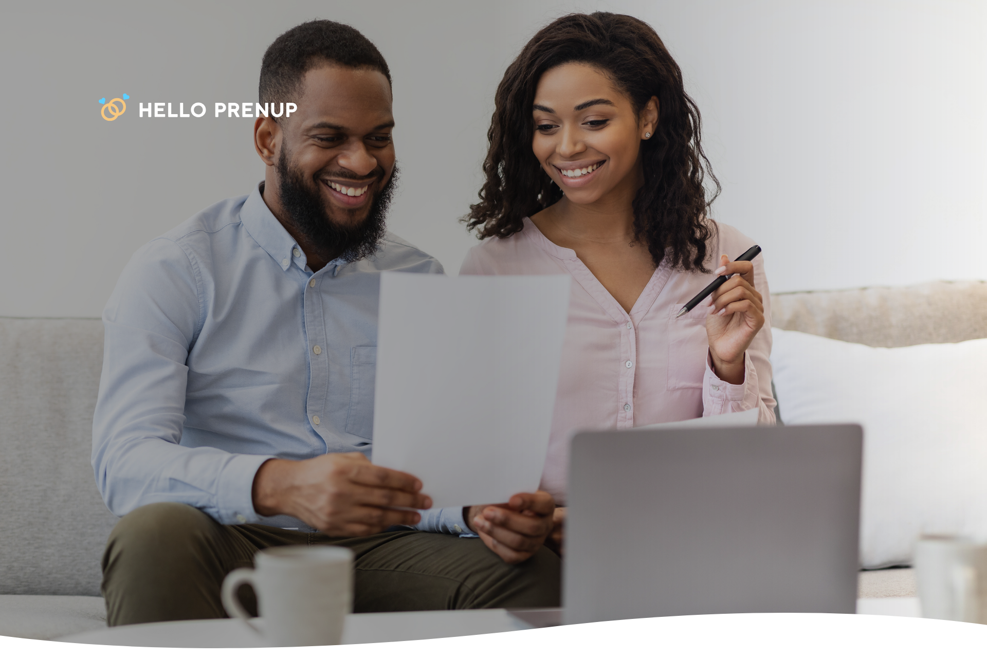 A couple sitting at a table with coffee, looking at documents and having a thoughtful discussion, possibly about reviewing their postnuptial agreement.