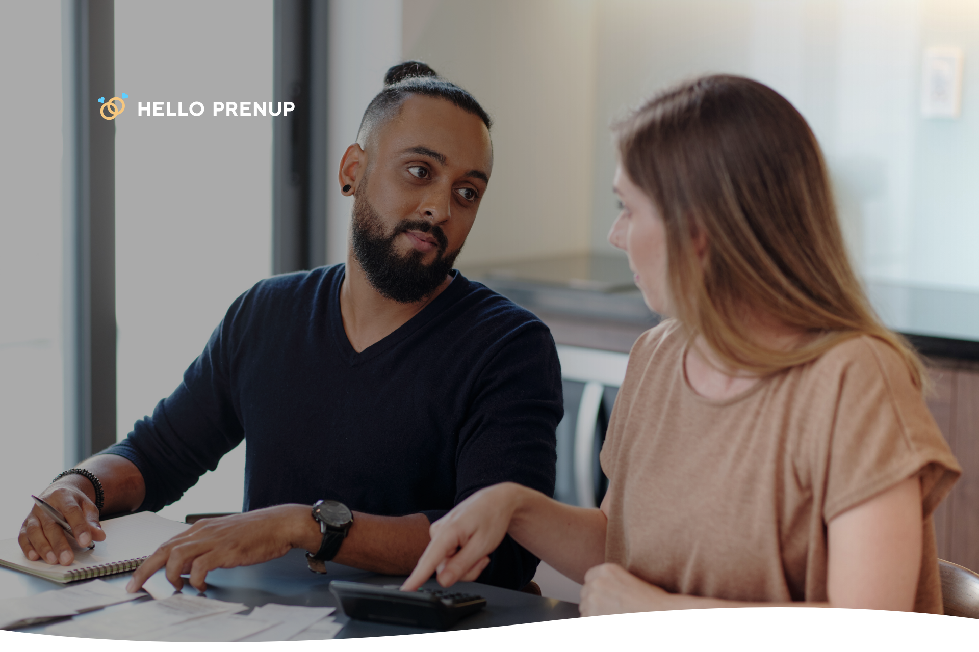 A couple sitting at a table, calmly discussing financial documents, illustrating transparent financial planning.