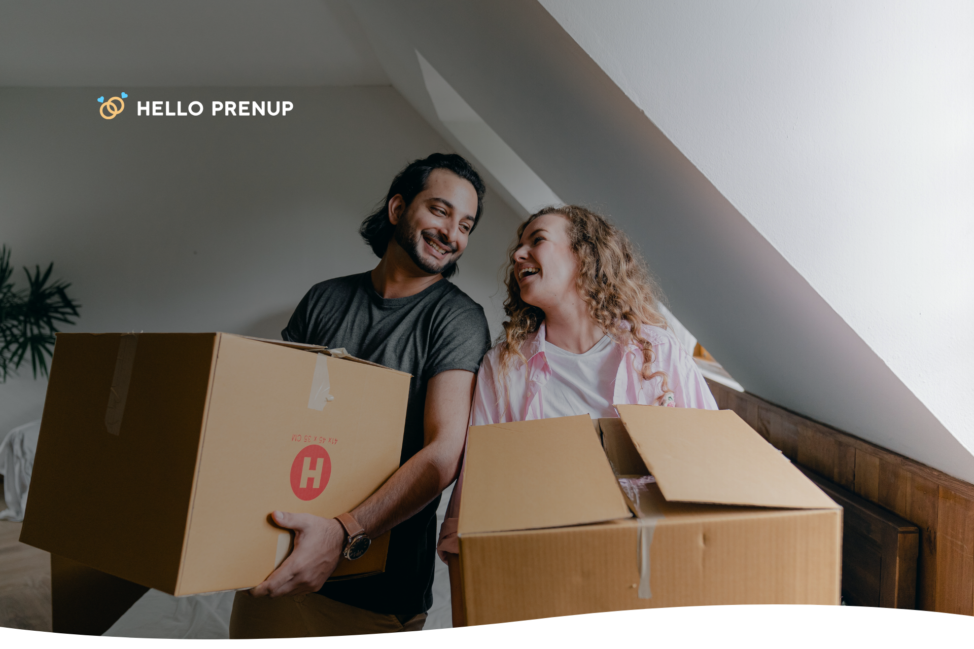 A young couple carrying moving boxes into their new apartment