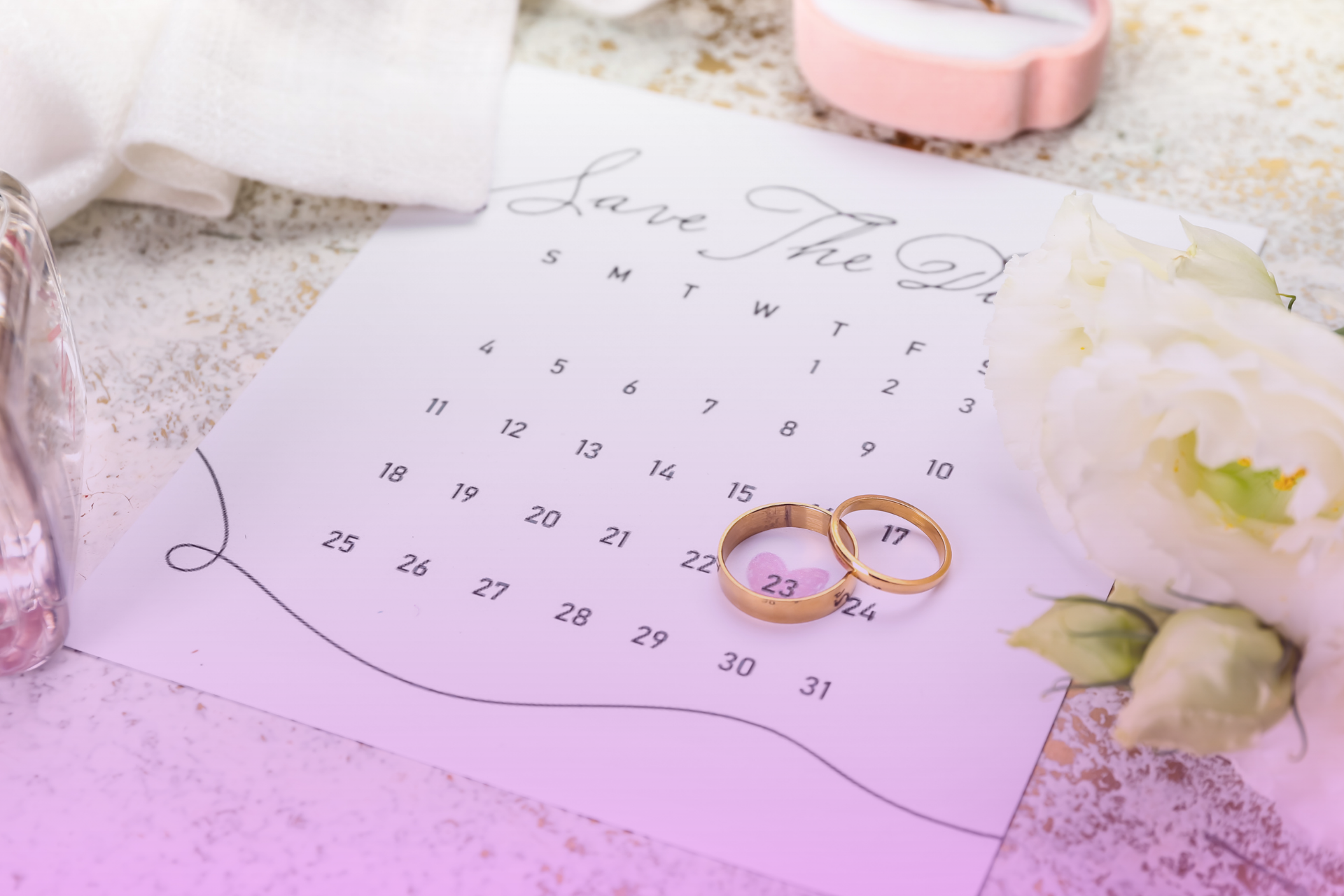 A close-up of an engagement ring in a jewelry box with a calendar in the background