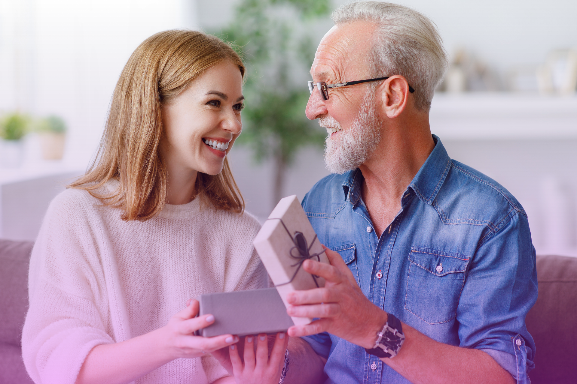 Parents handing a wrapped gift or an envelope to a young couple, illustrating a financial contribution that might need to be protected in a prenup.
