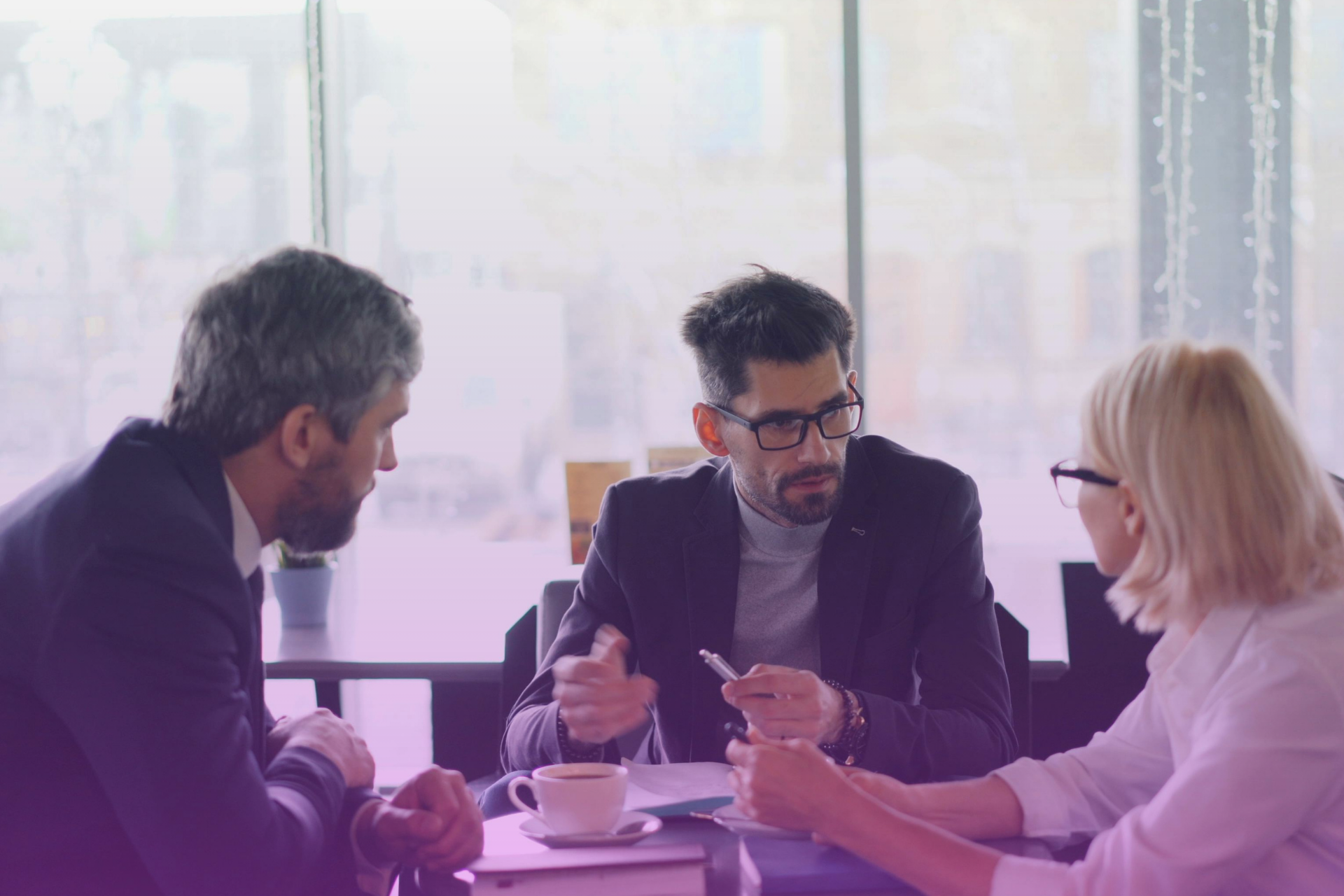 A group of people engaged in a serious but calm discussion around a table, indicating family communication