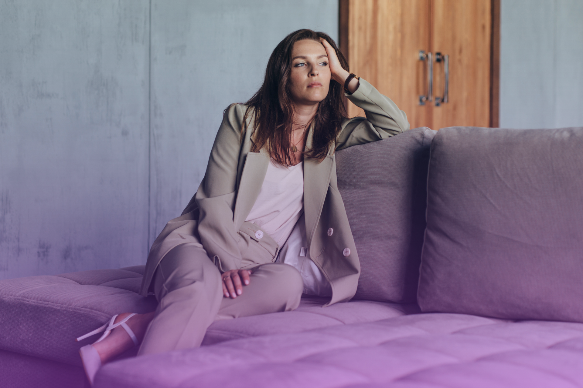 Woman sitting alone on a couch in deep thought
