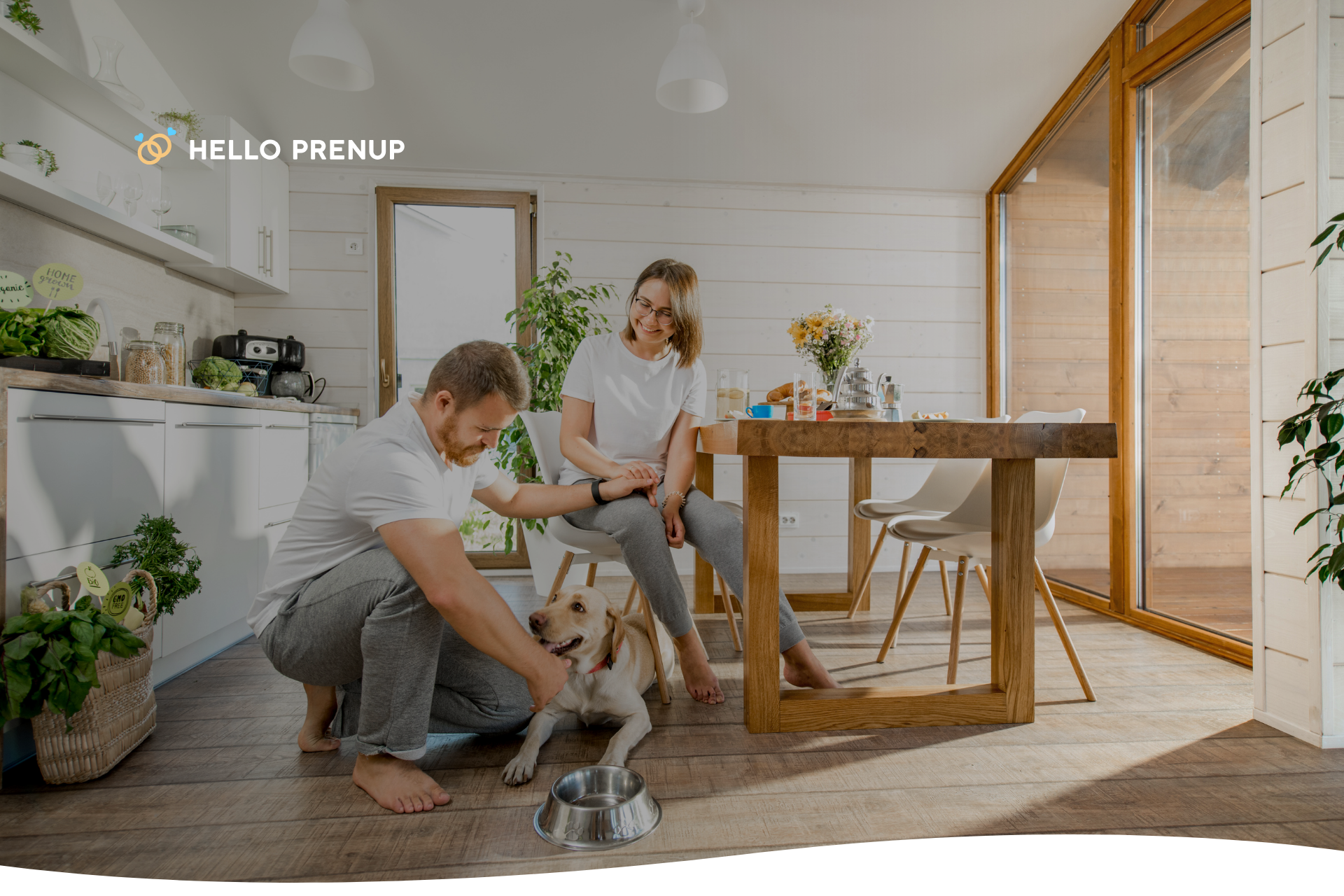 A happy couple playing with their dog inside a home, symbolizing the bond with family pets.
