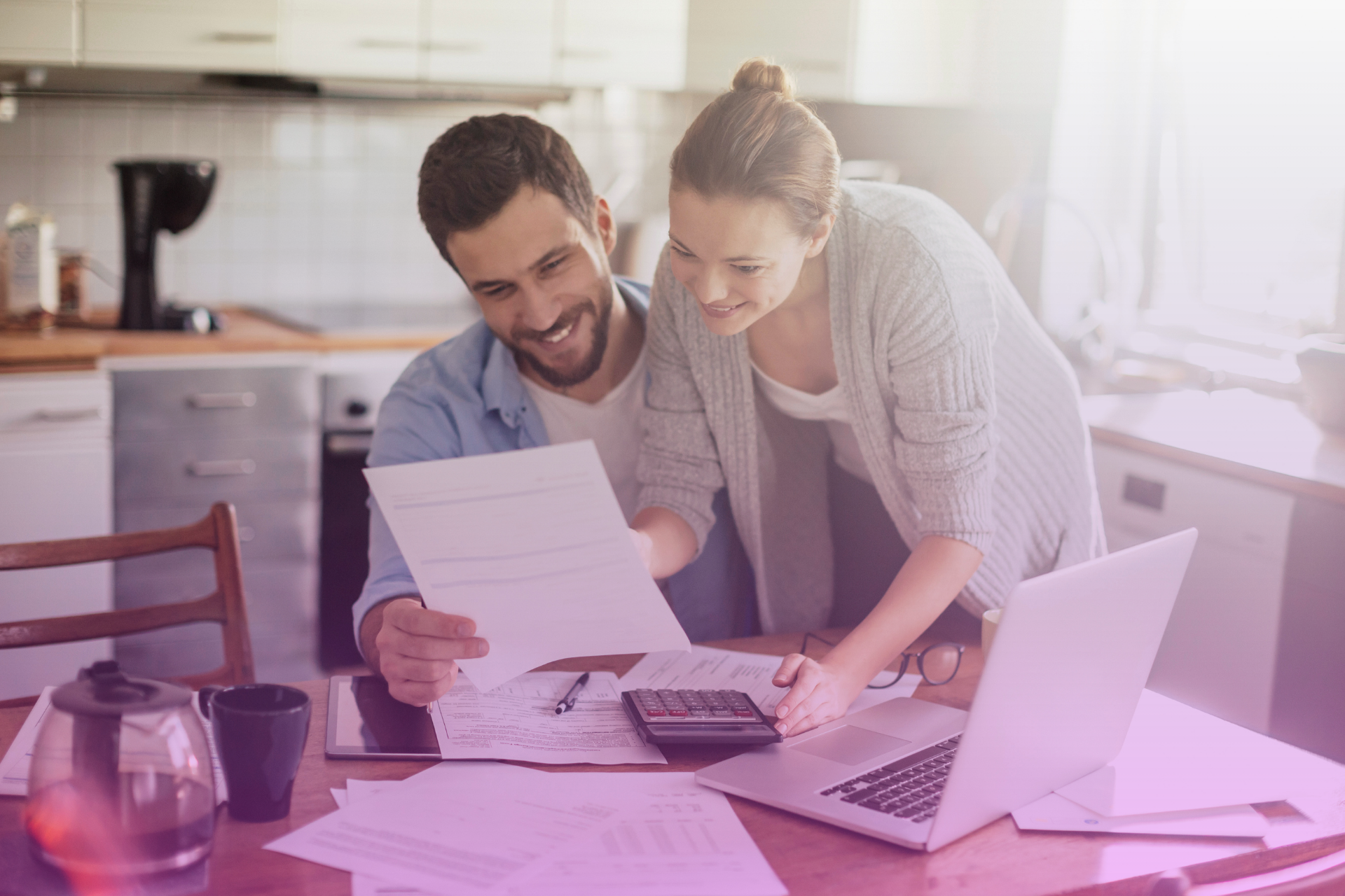 A couple sitting together, collaboratively working on a household budget on a laptop, showing teamwork in financial planning.