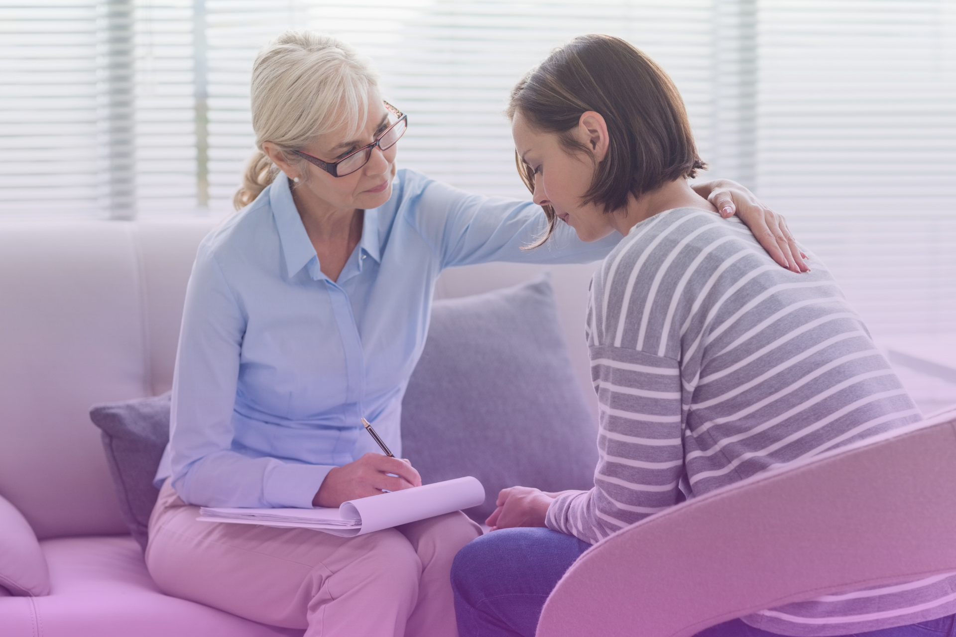 A therapist actively listening to a client in a comfortable, safe setting, symbolizing the healing process through professional help.