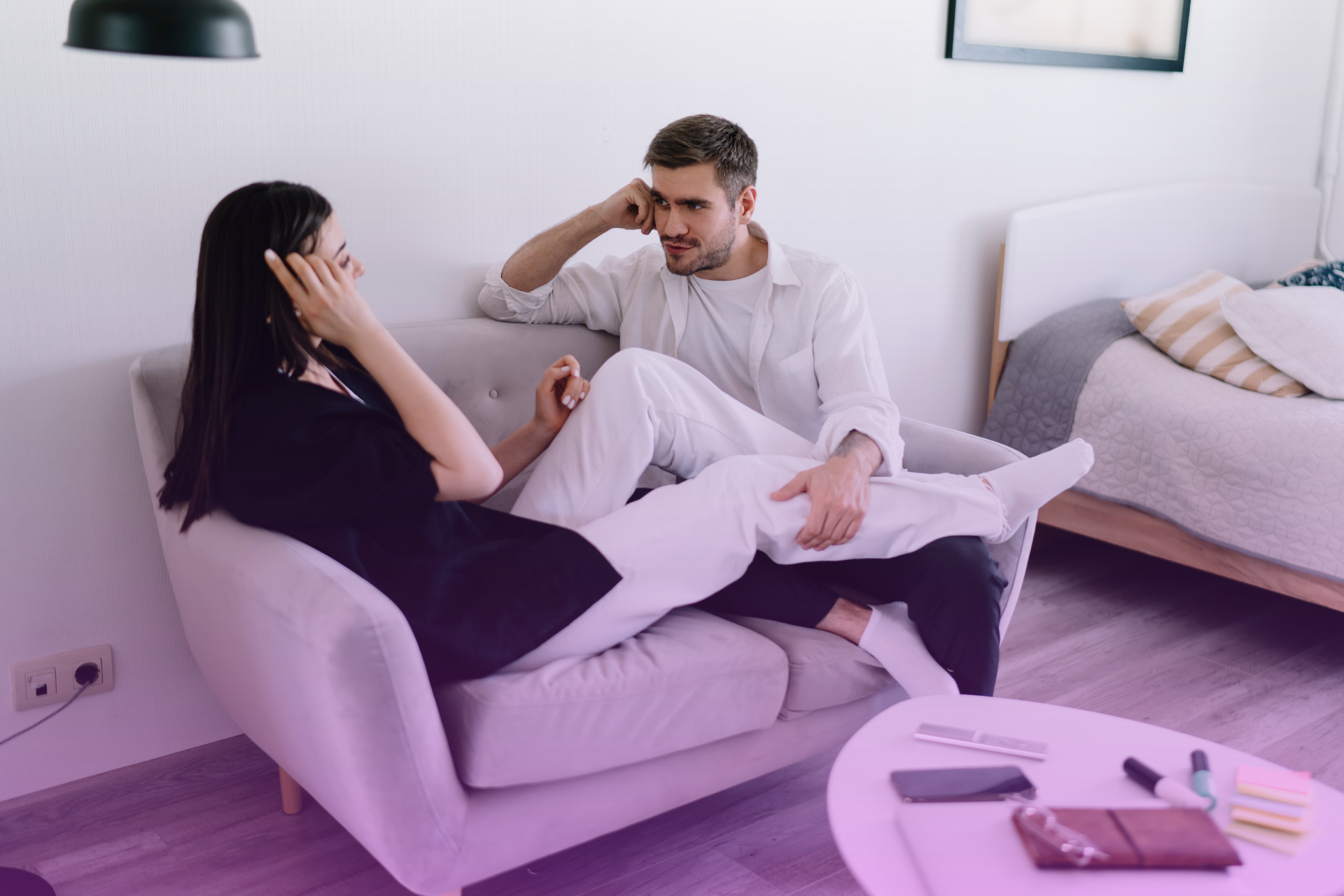 A couple sits on a couch, having a serious and calm discussion, symbolizing the ability to handle difficult topics with maturity.
