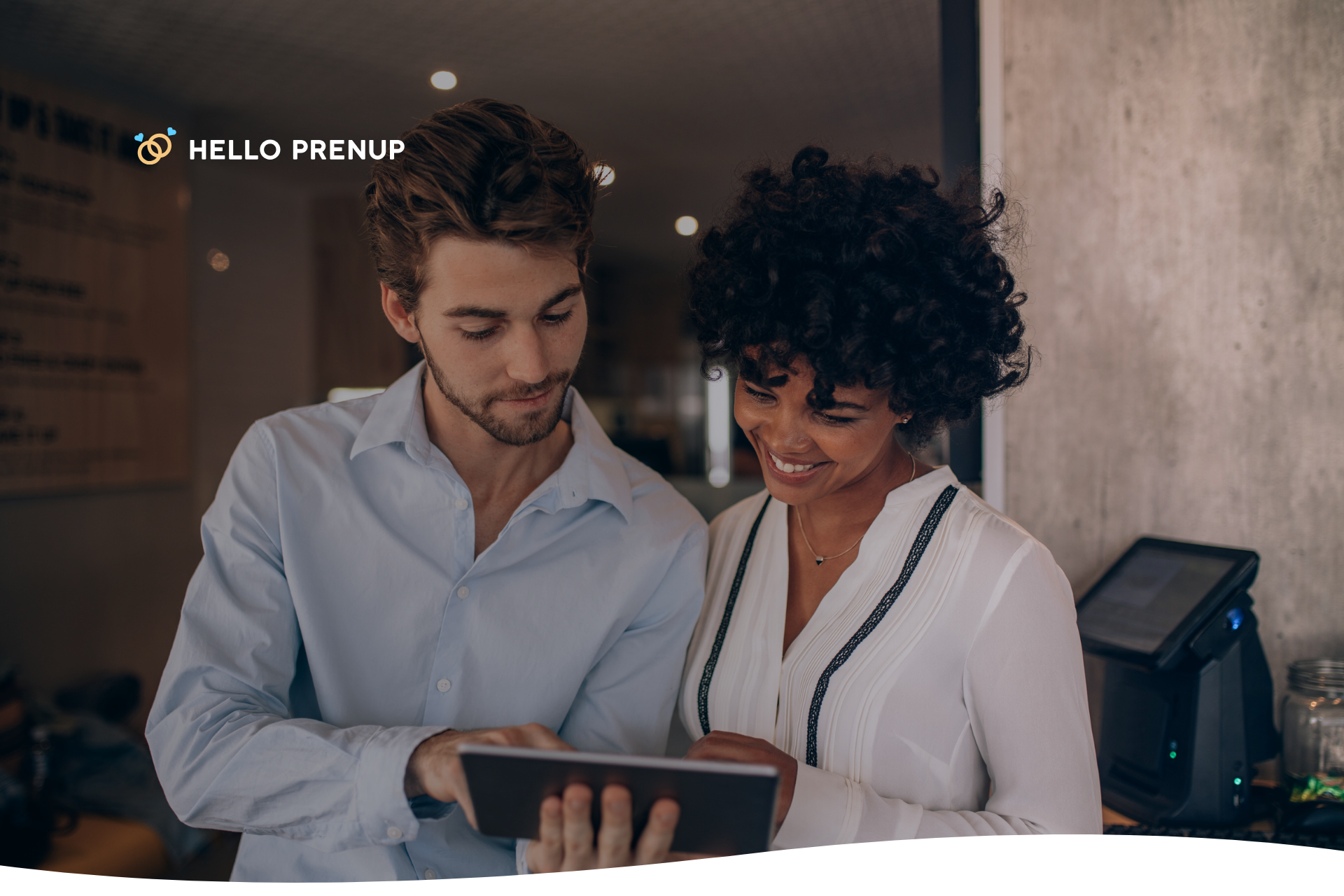 A woman holds her health insurance card and points to it while her partner listens, representing a conversation about who will be covered.