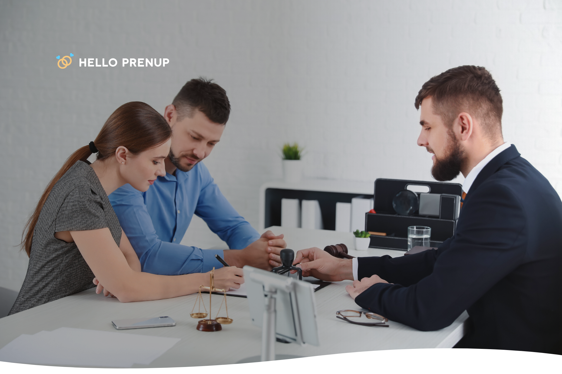 A couple sitting with a lawyer, reviewing complex legal documents related to a prenuptial agreement in Alabama.