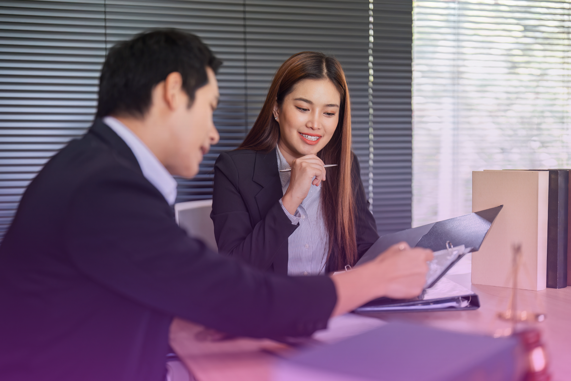 A couple sitting with a lawyer in Maryland, looking at legal documents, symbolizing professional guidance for their prenup.