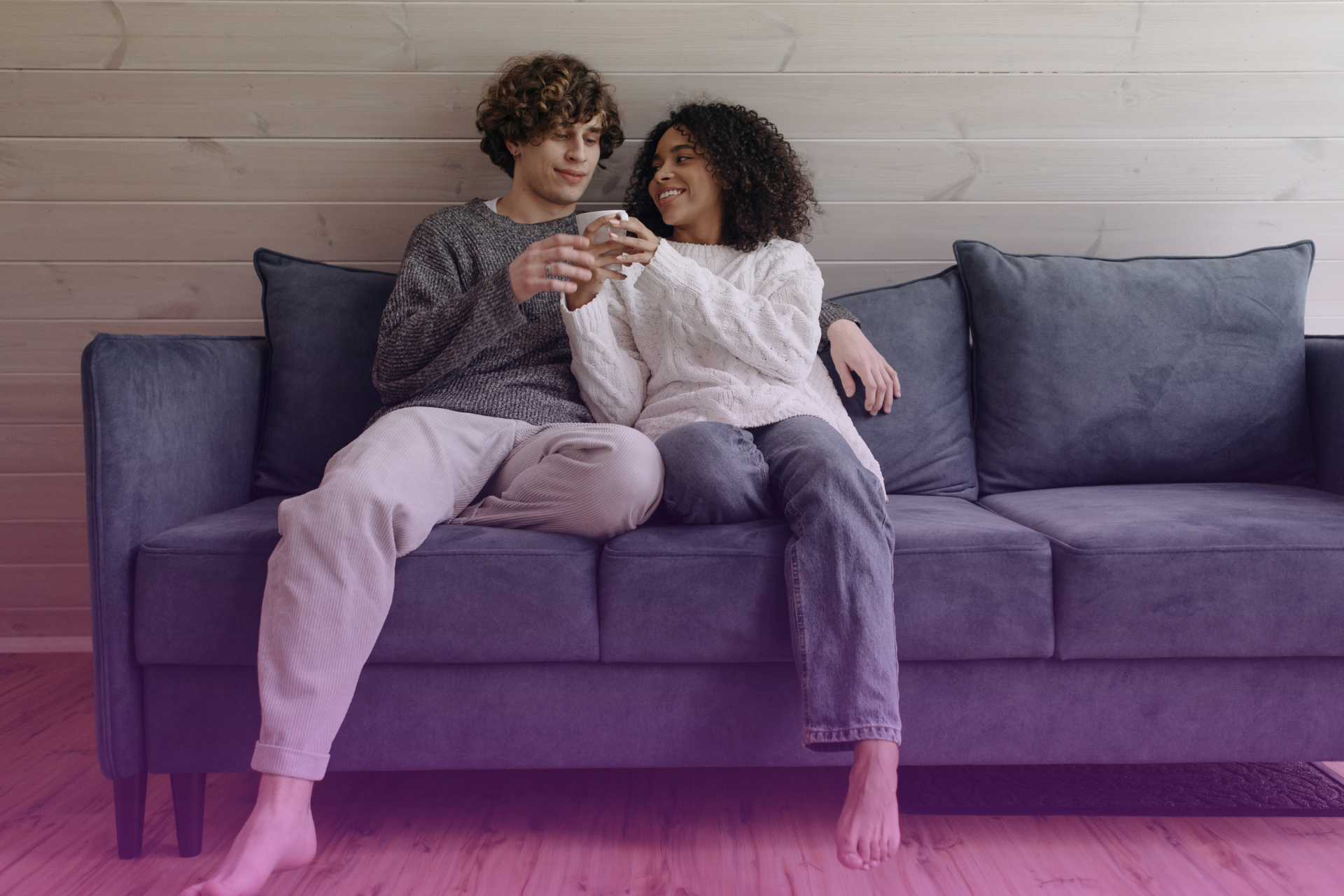 A couple sits on a couch, leaning into a calm and open conversation, representing a serious but non-confrontational discussion.