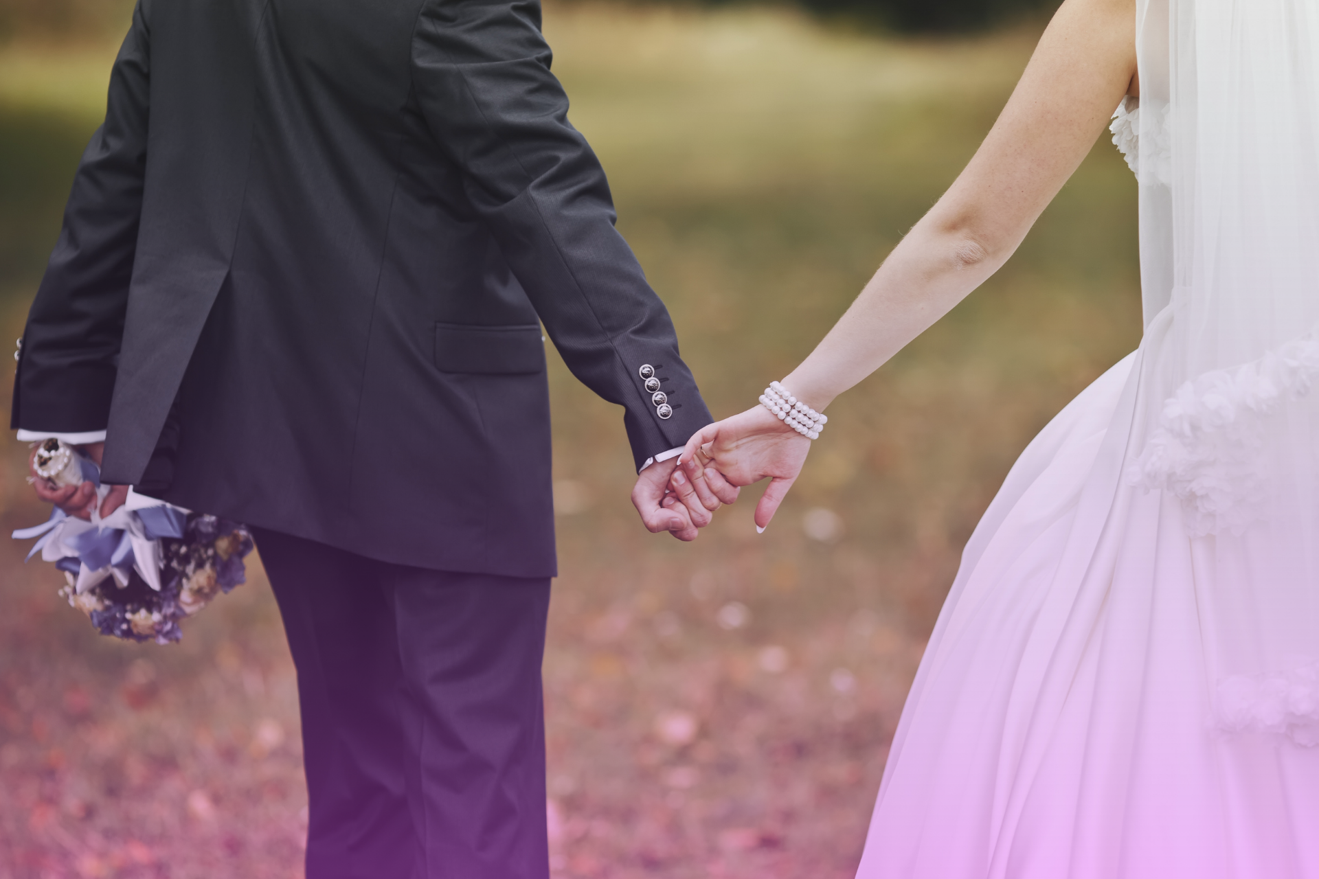 A bride and groom hold hands and walk together, symbolizing a shared journey and a clear financial path forward.