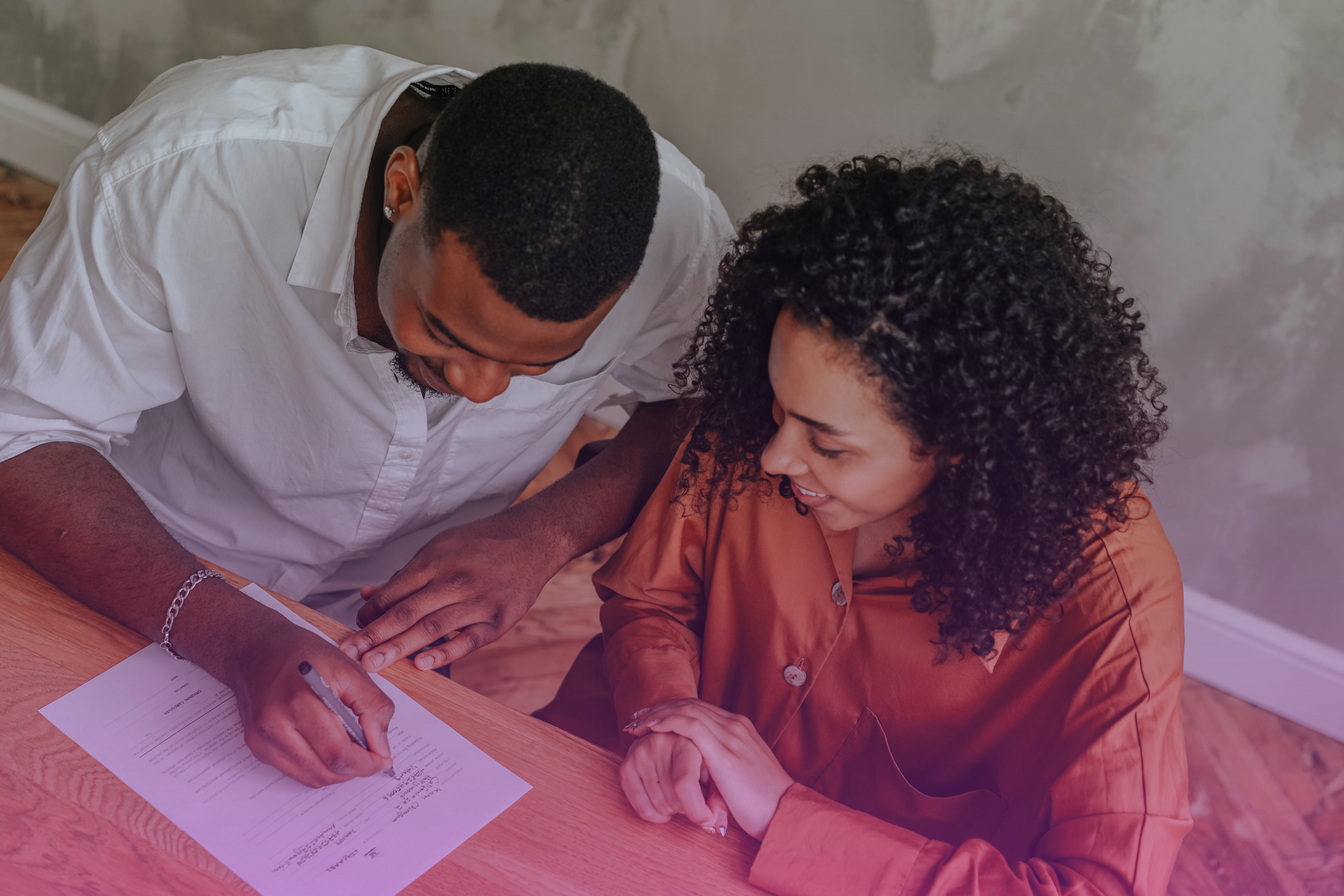 A couple sits together at a table, having a serious and open discussion about legal paperwork.