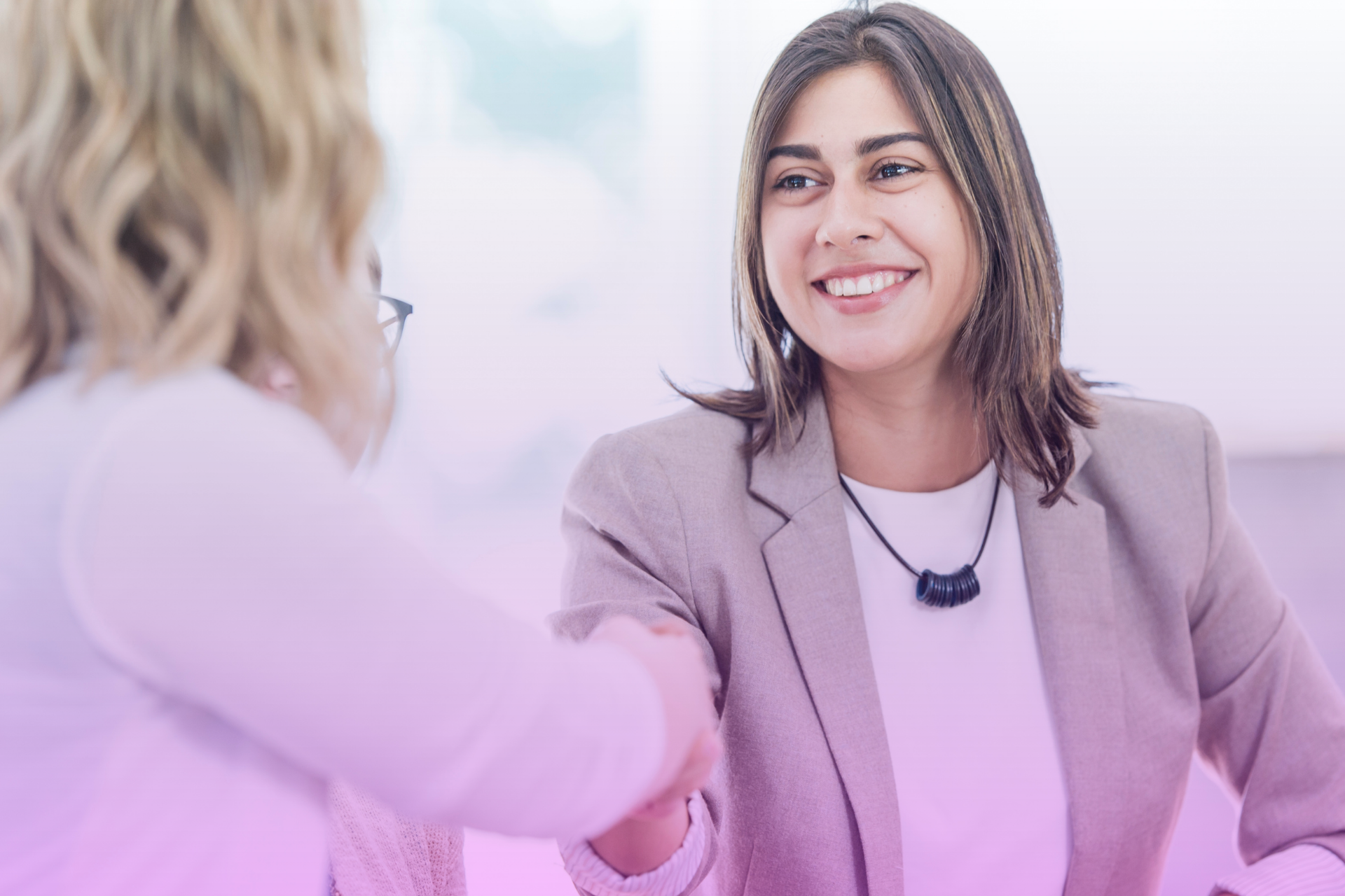 A couple smiles and shakes hands after a serious talk, symbolizing a fair agreement and a positive resolution of financial planning.