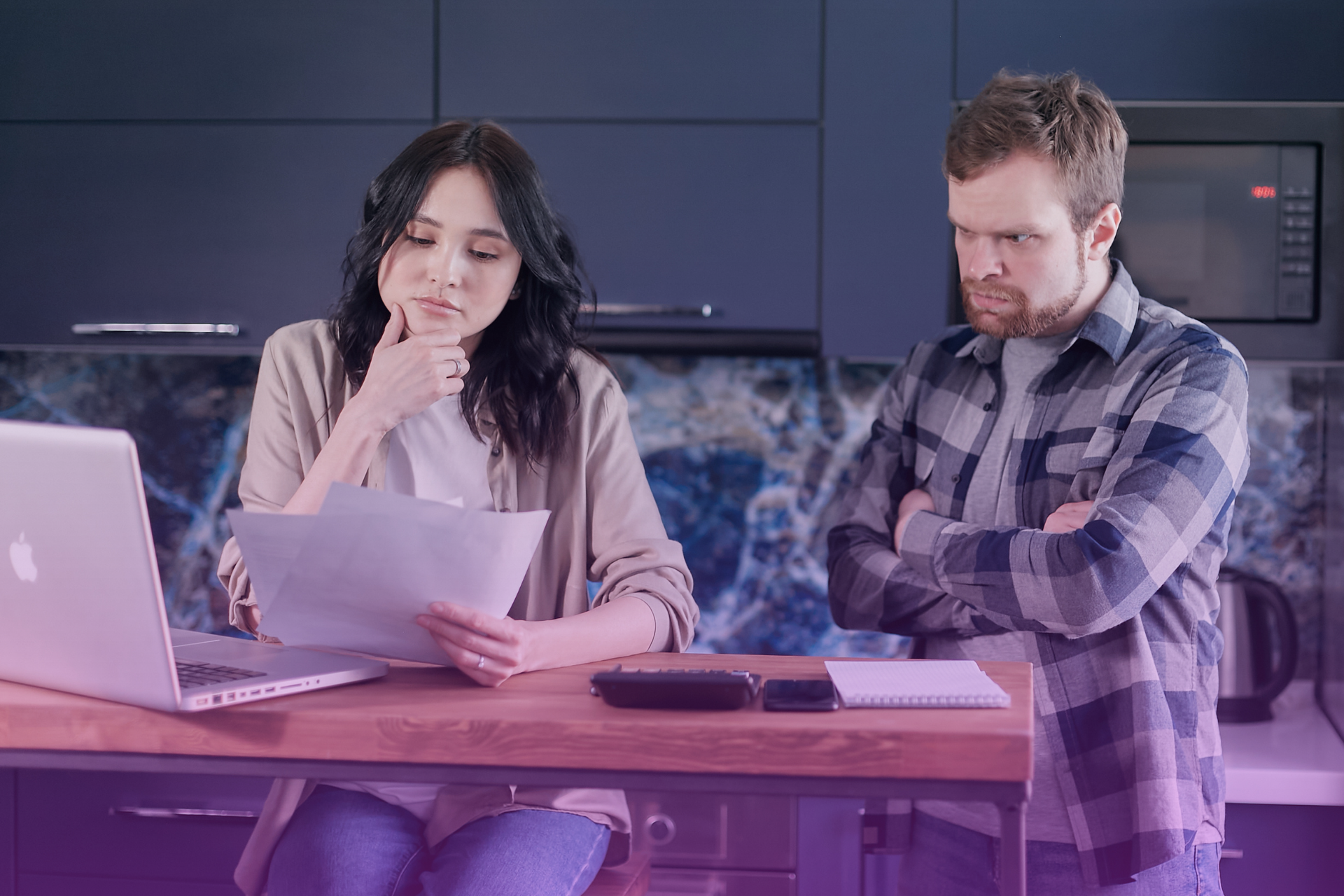 A couple looks at a prenup document on a tablet, representing the financial transparency needed for an agreement.