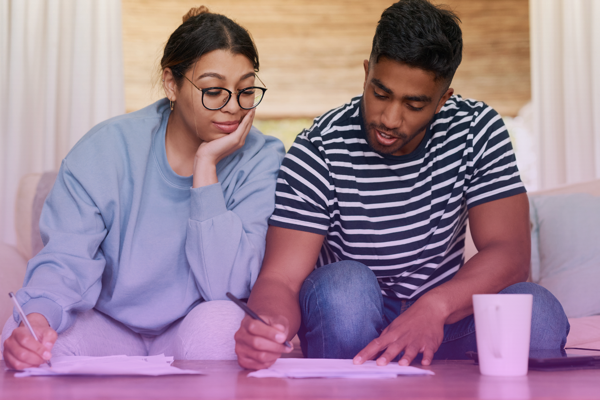 A couple signs a legal document together, representing the joint decision to create a will.